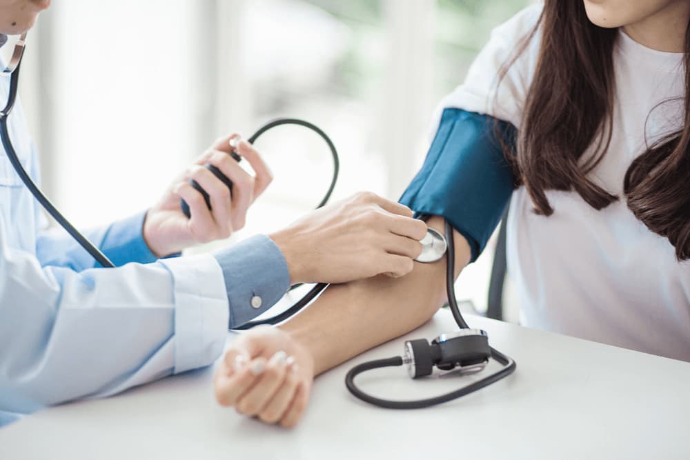 Medical Doctor Checking Woman's Blood Pressure