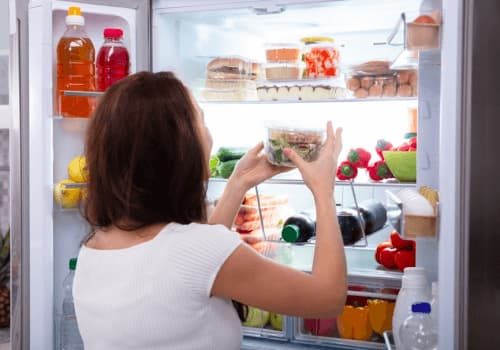 Woman Putting Meals In Her Fridge